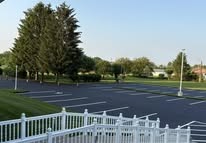 Freshly sealed and striped parking lot with white fence